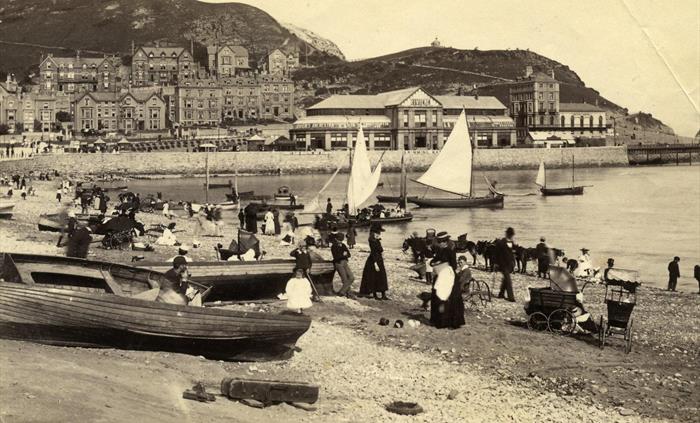 The Pier Pavilion in the background, sailing boats offering trips around the bay and donkey rides along the beach.